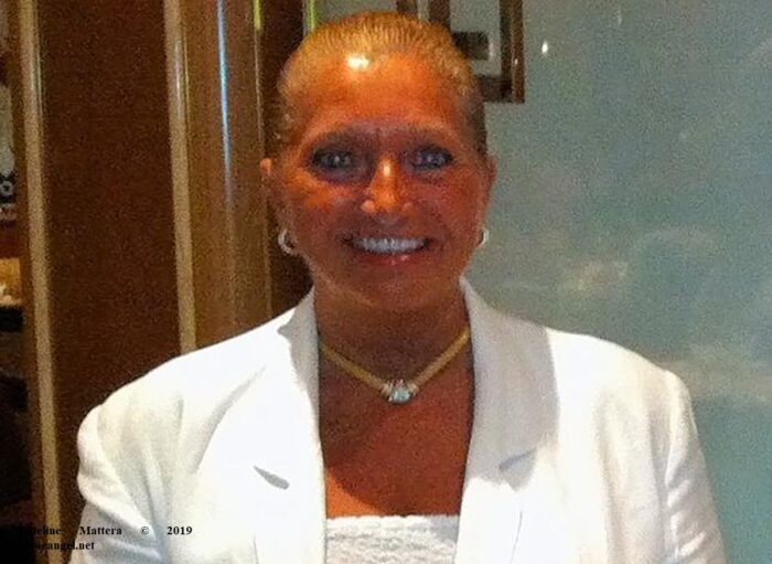 Smiling woman in white blazer and necklace