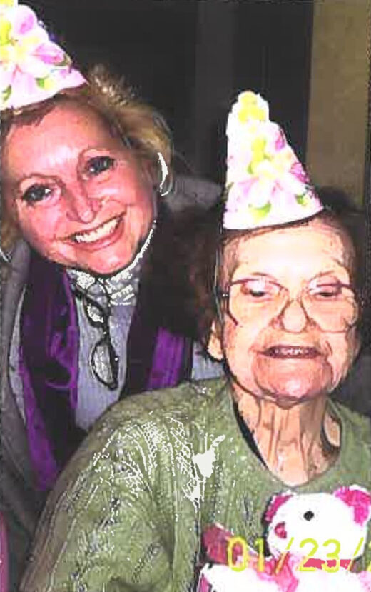 Two women smiling in floral party hats